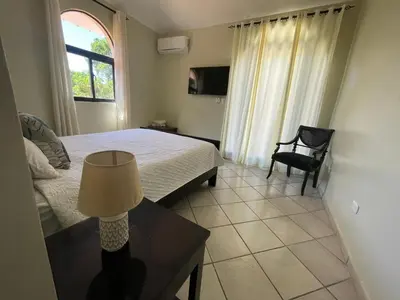 a bedroom with a bed and a table with a lamp at Villa Michel in Laguna del Higüero