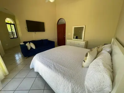 a bedroom with a white bed and a blue couch at Villa Michel in Laguna del Higüero