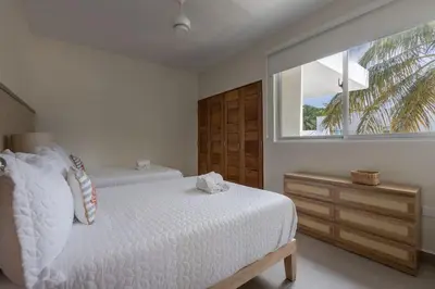 a white bedroom with a bed and a window at Caribey 2, Las Terrenas in Las Terrenas