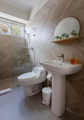 a bathroom with a sink and a toilet and a mirror at Caribey 2, Las Terrenas in Las Terrenas