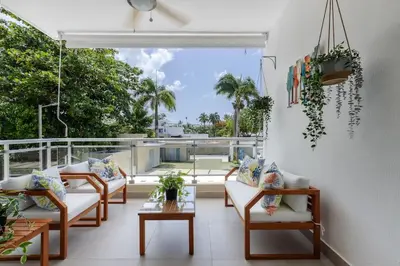 a porch with chairs and tables and a view of the ocean at Caribey 2, Las Terrenas in Las Terrenas
