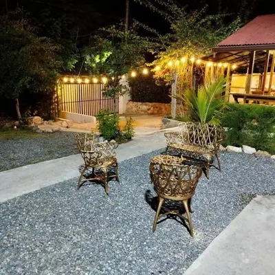 two chairs and a table in a yard with lights at Estancia La Esperanza in Jarabacoa