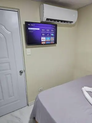 a room with a bed and a tv on the wall at hermoso aparta estudio a 10 minutos del centro in San Felipe de Puerto Plata