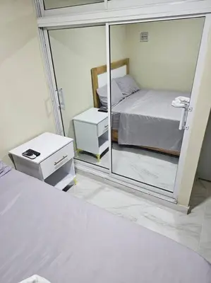 a bedroom with a bed and a large mirror at hermoso aparta estudio a 10 minutos del centro in San Felipe de Puerto Plata
