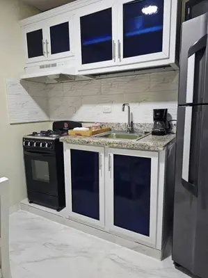 a kitchen with a sink and a black refrigerator at hermoso aparta estudio a 10 minutos del centro in San Felipe de Puerto Plata