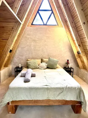 a large bed in a room with a large window at Leisy's Garden Hostel & Rooms in Santa Bárbara de Samaná