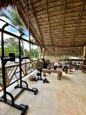 a gym with many exercise equipment in a building at Leisy's Garden Hostel & Rooms in Santa Bárbara de Samaná