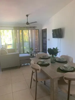 a living room with a wooden table and chairs at Jungle Oasis by the Beach in San Felipe de Puerto Plata