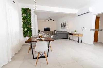a dining room and living room with a table and chairs at Elegant 2 Bedroom Apartment with Pool in La Laguna