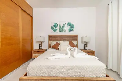 a bedroom with a bed with two swans on it at Elegant 2 Bedroom Apartment with Pool in La Laguna