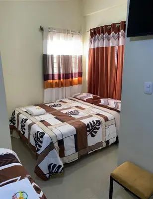 a bedroom with two beds and a window at Hotel El Parque Constanza in Constanza