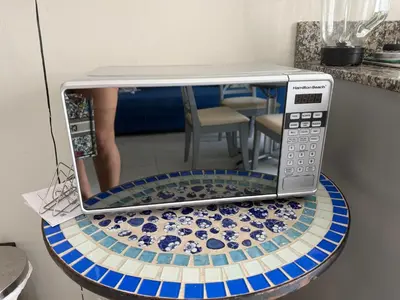 a microwave oven with a reflection of a woman in it at Cadaques Caribe Palmera 101 in Bayahibe