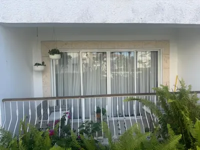 a balcony with plants in front of a window at Cadaques Caribe Palmera 101 in Bayahibe