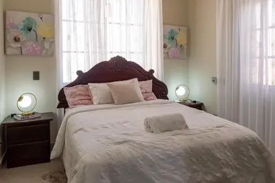 a bedroom with a large bed with two lamps on tables at Casa familiar con piscina y cerca de la playa in La Belleza