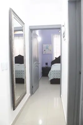 a hallway with a mirror and a bed in a room at Casa familiar con piscina y cerca de la playa in La Belleza