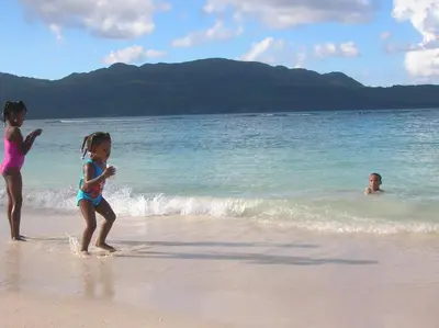 three children playing in the water on the beach at Casa Por Que No in Las Galeras