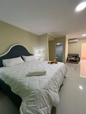a bedroom with a large bed with a white comforter at Hotel El Imperio Punta Cana in Punta Cana