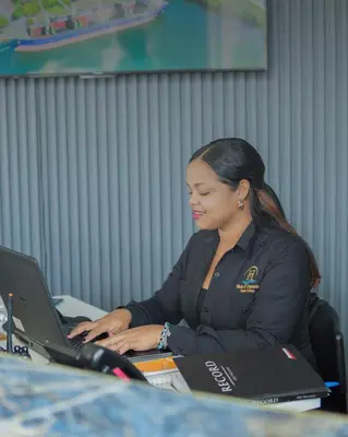 a woman sitting at a desk using a laptop computer at Hotel El Imperio Punta Cana in Punta Cana