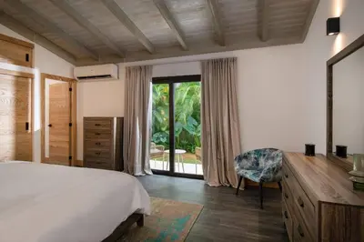 a bedroom with a bed and a desk and a window at Villa Laguna, Lush Oasis In Casa De Campo in La Romana