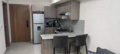 a kitchen with a refrigerator and a counter with chairs at Boca del Mar III, Boca Chica in Boca Chica
