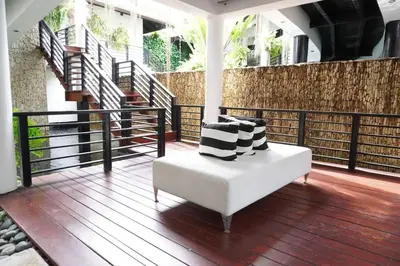 a white couch with pillows on a balcony with stairs at Villa Alpes, Exquisite Retreat In Casa De Campo in La Romana