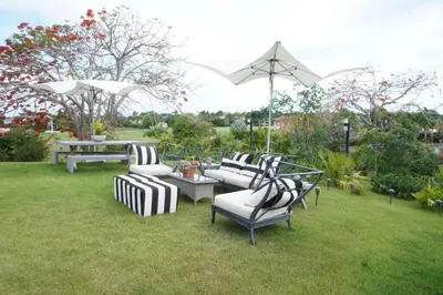 a group of chairs and tables in a yard at Villa Alpes, Exquisite Retreat In Casa De Campo in La Romana