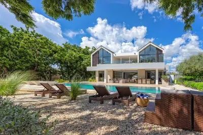 a villa with a swimming pool and a house at Villa Polos, Prestigious Haven In Casa De Campo in La Romana