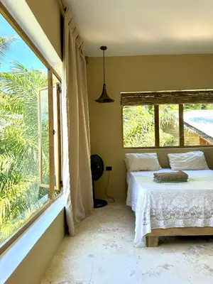 a bedroom with a bed and a large window at Suami s room Casa Padura in Cabarete