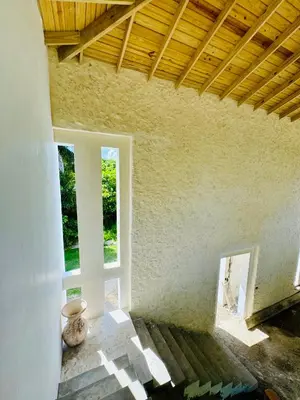an empty room with two windows and a wooden ceiling at Suami s room Casa Padura in Cabarete