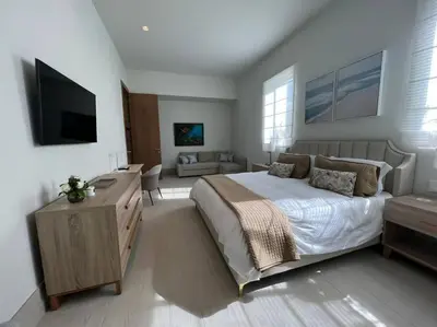 a bedroom with a bed and a living room at Villa Pradera, Upscale Comfort In Casa De Campo in La Romana