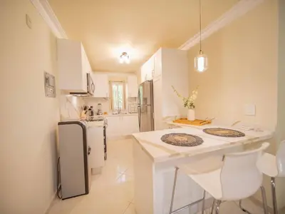 a kitchen with white counters and a white refrigerator at Garden Condos 21, Modern 1BR APT In Sosua Strip GUEST FRIENDLY in Sosúa