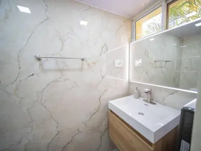 a bathroom with a sink and a marble wall at Garden Condos 21, Modern 1BR APT In Sosua Strip GUEST FRIENDLY in Sosúa