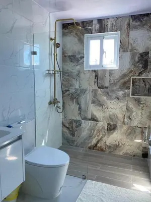 a bathroom with a toilet and a glass shower at Sunrise ApartaHotel in El Manguito