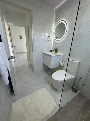 a bathroom with a toilet and a sink and a mirror at Sunrise ApartaHotel in El Manguito