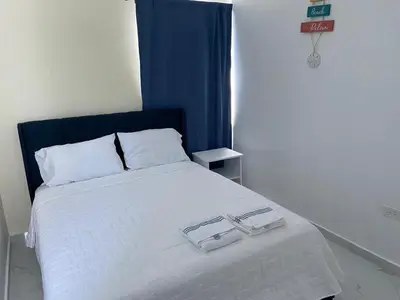 a bedroom with a bed with two glasses on it at Sunrise ApartaHotel in El Manguito
