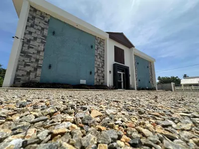 a building with a stone ground in front of it at Sunrise ApartaHotel in El Manguito