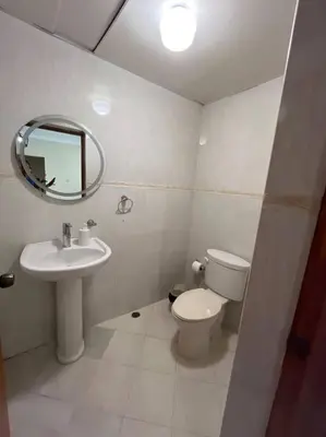 a bathroom with a sink and a toilet and a mirror at Central Oasis Work or Explore the city in Santo Domingo