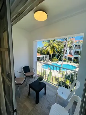 a room with a balcony with a view of a pool at The Best Place in los Corales RD Arenas De B in Punta Cana