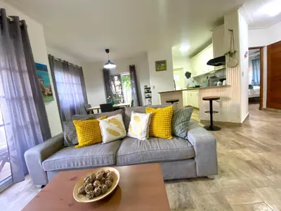 a living room with a gray couch with yellow pillows at The Best Place in los Corales RD Arenas De B in Punta Cana