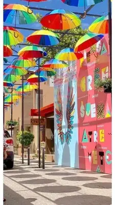 a bunch of colorful umbrellas hanging from a building at Tropical Estudio En El Centro De La Ciudad in San Felipe de Puerto Plata