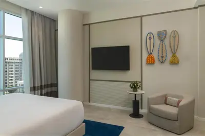 a bedroom with a bed and a chair and a television at Hyatt Centric Santo Domingo in Santo Domingo