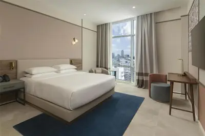 a bedroom with a bed and a desk and a window at Hyatt Centric Santo Domingo in Santo Domingo