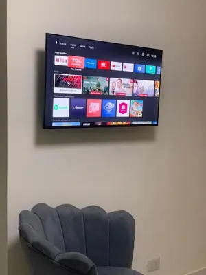 a television hanging on a wall with a couch at Mi Refugio in San Fernando de Monte Cristi