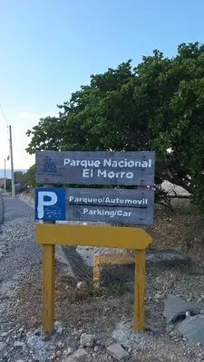a wooden sign on the side of a road at Mi Refugio in San Fernando de Monte Cristi