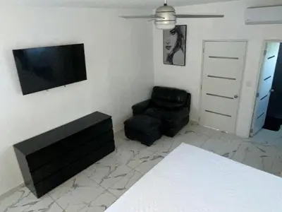 a living room with a chair and a flat screen tv at LEVEL suites #4 OMEGA in Sosúa