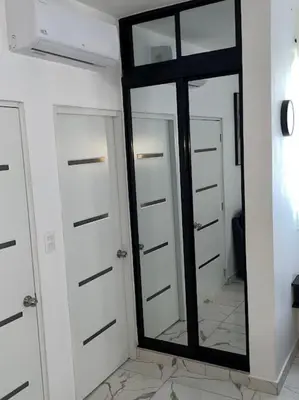 a bathroom with white doors and a large mirror at LEVEL suites #4 OMEGA in Sosúa