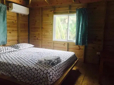 a bedroom with a bed in a log cabin at Mango House Big air studio in Cabarete
