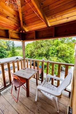 a wooden porch with a table and chairs on it at Mango House Big air studio in Cabarete