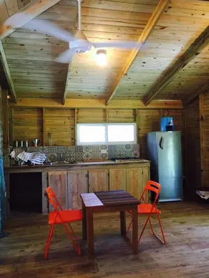a kitchen with a table and two chairs and a refrigerator at Mango House Big air studio in Cabarete