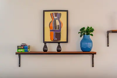 a shelf with a painting and a vase on it at la maguana - cozy and beautiful 3BR home with pool in Santiago de los Caballeros